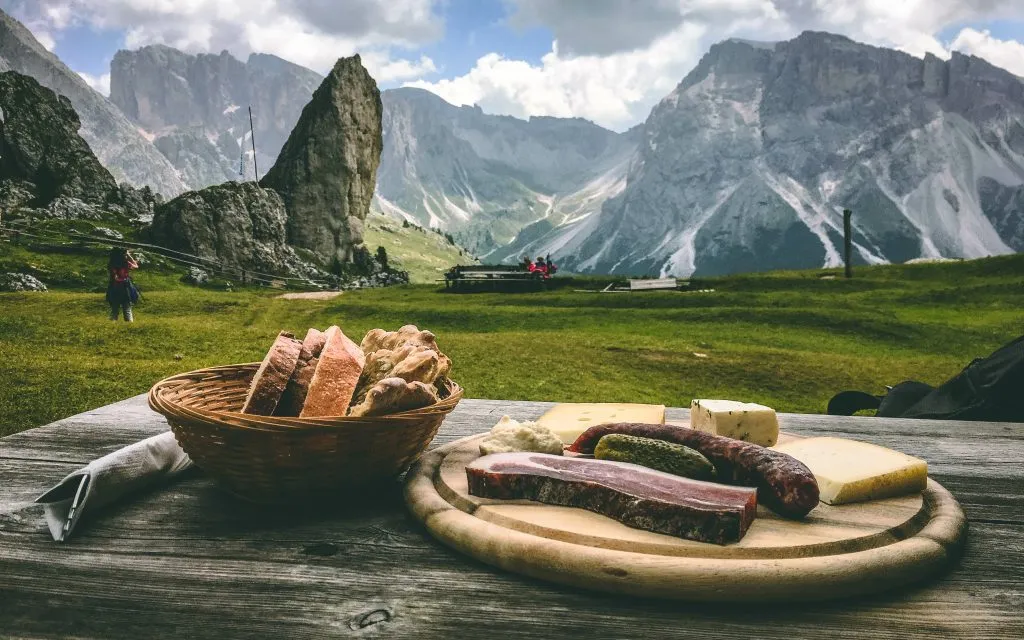 Sorprendente comida alpina de montaña: salchichas ahumadas y queso. Comida italiana de montaña